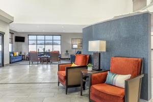 纳科多奇斯Comfort Suites Nacogdoches的大堂设有橙色椅子和客厅。