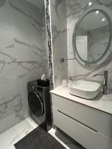 La Celle-Saint-CloudLuxueux Appartement Jacuzzi proche de Paris的一间带水槽和镜子的浴室以及一台洗衣机
