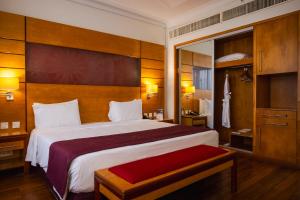 拉各斯Eko Hotel Suites的配有一张大床和镜子的酒店客房