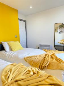 伊登Flat 401 Spacious Two Bedroom的一间卧室设有两张床和黄色的墙壁