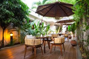 拉各斯Eko Hotel Suites的一个带桌椅和遮阳伞的户外庭院。