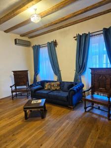 锡吉什瓦拉The Throne - M Museum Hotel的客厅配有蓝色的沙发和桌子