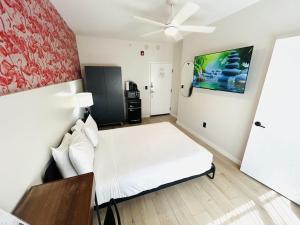 迈阿密海滩Greenview Hotel By Lowkl的卧室配有白色的床和吊扇