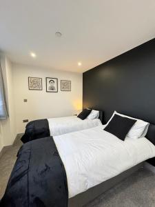 伊登Flat 501 Chic Apartment Living的卧室设有两张床,拥有黑色的墙壁