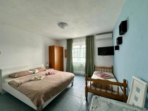 蒂瓦特Maki Apartments - Plavi Horizonti Beach的酒店客房设有两张床和电视。