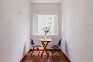 利马Miraflores Private Rooms - Guest House - Cocina Compartida - Terraza的一张桌子,两把椅子,花瓶上放着鲜花