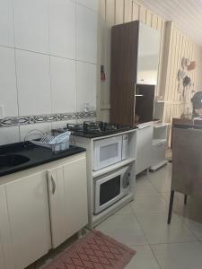 邦比尼亚斯Casa 01,02的厨房配有白色橱柜和炉灶烤箱。