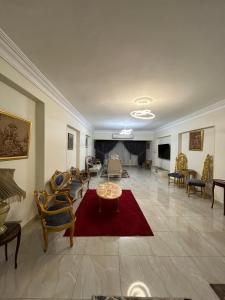 开罗ميدان المساحه الدقي的一个带椅子和红色地毯的大客厅