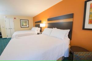 俾斯麦俾斯麦戴斯酒店的酒店客房设有两张白色的床和橙色的墙壁