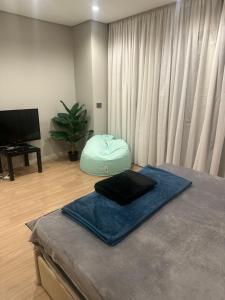 开罗Oriana Villa Guest House的一间设有一张带搁脚凳的床和电视的客房