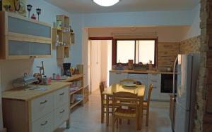 拉纳卡Destalo Court Larnaca Apartment的一间带桌椅的厨房和一间带冰箱的厨房