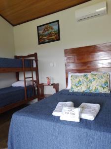圣罗克迪米纳斯Refúgio Pé da Serra - Chalés的一间卧室配有蓝色的床和2条毛巾