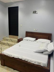 科托努Timba belleVilla的一张带白色床单和枕头的床
