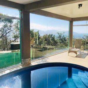 加罗帕巴Silveira Eco Village Residence的一座带大窗户的房屋内的游泳池