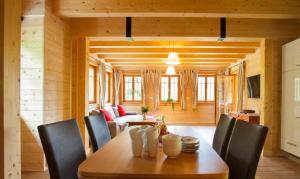 巴德艾森卡珀尔Arlitscherhof Ferienwohnungen und Chalets的一间带木桌和椅子的用餐室