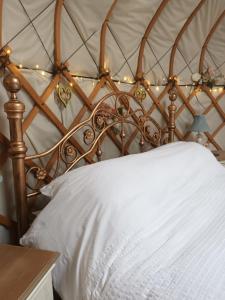 东迪勒姆Gingerbread Cottage Yurts的一张带木质床头板和灯的床