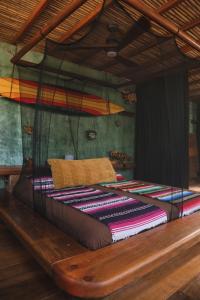 埃斯孔迪多港夫鲁塔斯沃尔杜拉斯旅舍的一张床上有色彩缤纷的毯子,放在房间里