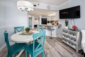 沃尔顿堡滩Nautilus 2308 Gulf View 2 Bedroom 3rd Floor Free Beach Service的厨房以及带白色桌子和蓝色椅子的用餐室。