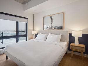 梅戈格Hôtel - Expérience - Quartier Des Marinas的卧室设有白色的床和大窗户