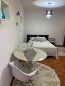 圣保罗Edícula tranquila e bem localizada no Butantã的白色的客房配有一张床、一张桌子和椅子