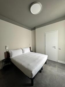 米兰22马索酒店的一间卧室配有一张白色大床和光线