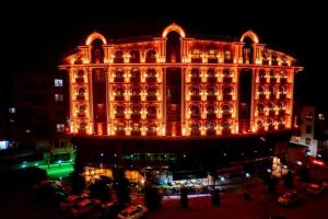 安塔利亚Can Adalya Palace Hotel的一座大建筑在晚上点燃