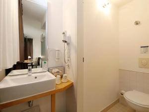 柏林B&B HOTEL Berlin-Mitte的白色的浴室设有水槽和卫生间。