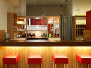 柏林B&B HOTEL Berlin-Mitte的一间酒吧,在房间里设有红色凳子