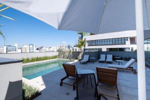 圣保罗MARCOLINI - Flat Luxo Bela Cintra的一个带桌椅的庭院和一个游泳池