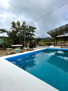 GuayabalMiravalles Volcano House的一个带野餐桌的大型蓝色游泳池