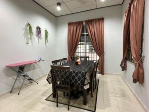 瓜拉丁加奴HOMESTAY IZHAN BANDAR KUALA TERENGGANU的一间带桌椅和窗户的用餐室