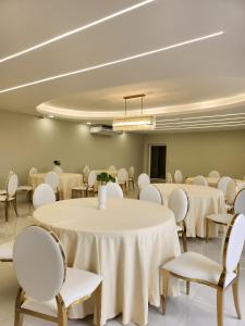 Santa ElenaHotel Tepeu的一间会议室,配有白色的桌椅