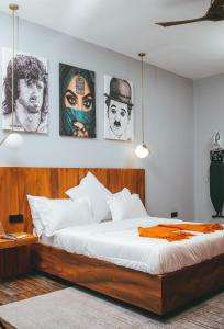 布琼布拉Burundi Palace Boutique Hotel的卧室配有一张四幅画的墙壁床。