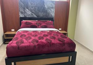 帕斯托Hotel Colonial House的一张带红色棉被和红色枕头的床