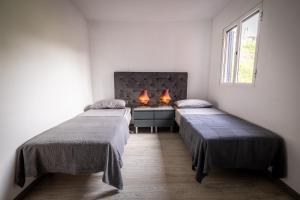 Quinta do AlmeidaPanoramic House的客房设有两张床和一张带两盏灯的书桌。