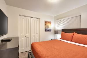 摩押6A Family Friendly RedCliff Condo POOL & HOT TUB (Pet Friendly)的一间卧室配有一张带橙色床罩的床和一张书桌