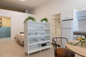 瓦伦西亚NEW BEACH flats VALENCIA的厨房设有白色的架子,配以餐具