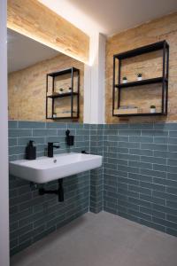 瓦伦西亚NEW BEACH flats VALENCIA的浴室设有白色水槽和蓝色瓷砖