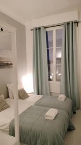 奥尔良Appartement avec belle vue sur la place du Martroi的一间卧室设有两张床和窗户。