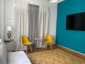 约阿尼纳Lait Hostel的一间卧室设有两张黄色椅子和蓝色的墙壁