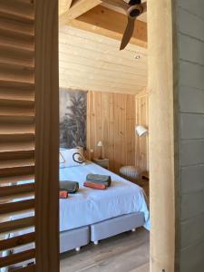 拉卡诺VillaCanau的卧室配有一张床铺,位于带木墙的房间内