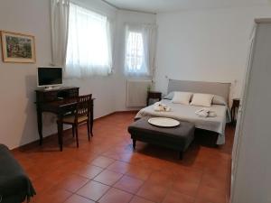PomaroloGrazioso appartamento tra cultura, lago e montagna的一间卧室配有一张床、一张桌子和一张书桌
