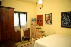圣乔瓦尼镇B&B Villa el Tango的一间卧室配有一张床、一个梳妆台和一扇窗户。