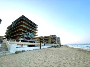 阿勒纳勒斯德尔索尔Arenales del sol, primera linea de playa的海边的一栋建筑