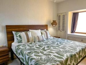 佩尼亚斯科港Princesa de Peñasco Condo D203 Sandy Beach Puerto Peñasco的一间卧室配有一张带绿色和白色棉被的床