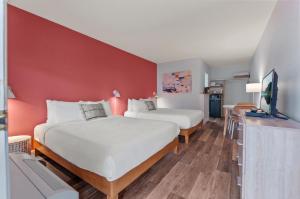 彭蒂克顿Okanagan Lakefront Resort的红色墙壁的客房内的两张床