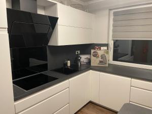 霍恩-巴特迈恩贝格Ferienwohnung Rosa - b48939的厨房配有白色橱柜和黑色台面