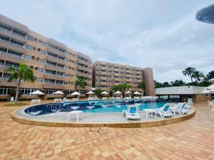 巴雷里尼亚斯Gran Lençóis Flat Residence的酒店前方的游泳池配有椅子和遮阳伞