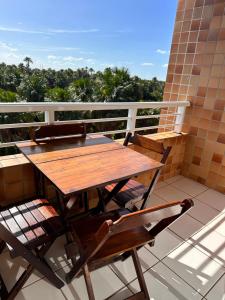 巴雷里尼亚斯Gran Lençóis Flat Residence的阳台上配有一张木桌和两把椅子