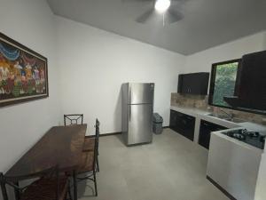 利比里亚Amazilia Guesthouse的厨房配有不锈钢冰箱和桌子